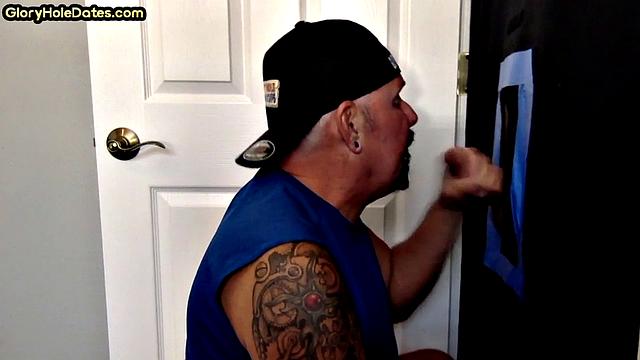 Deepthroating tattooed DILF sucks gloryhole penis