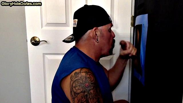 Deepthroating tattooed DILF sucks gloryhole penis
