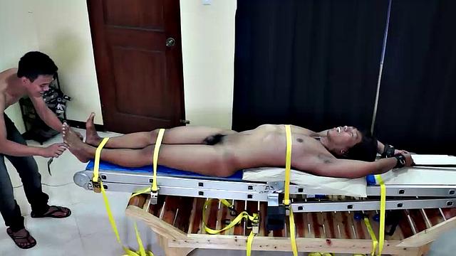 Gay Asian hottie Hermis is strapped down to the tickle rack and Warren plays with his hot cock.