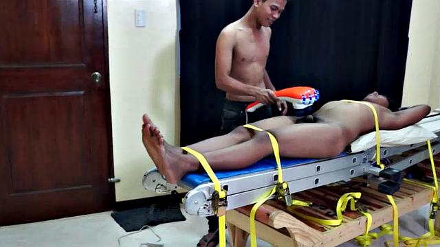 Gay Asian hottie Hermis is strapped down to the tickle rack and Warren plays with his hot cock.