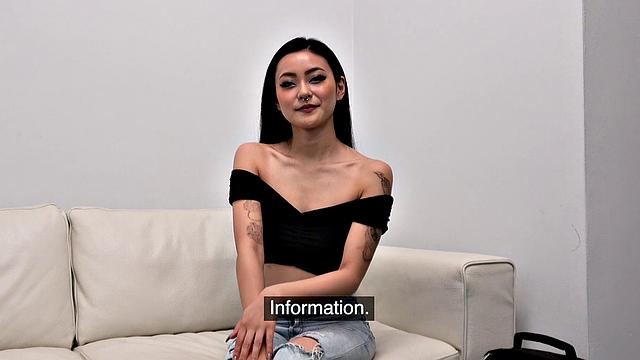 Watch this tattooed Asian babe get fucked doggystyle on the couch while wearing a piercing