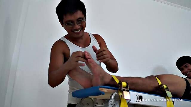 This ticklish Asian gay boy finds himself strapped down with two evil grinning ticklers ready to pounce. He's most definitely cute, and obviously quite ticklish.