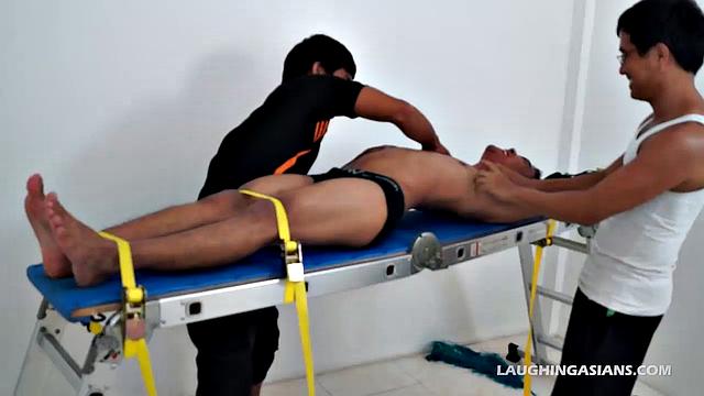 This ticklish Asian gay boy finds himself strapped down with two evil grinning ticklers ready to pounce. He's most definitely cute, and obviously quite ticklish.