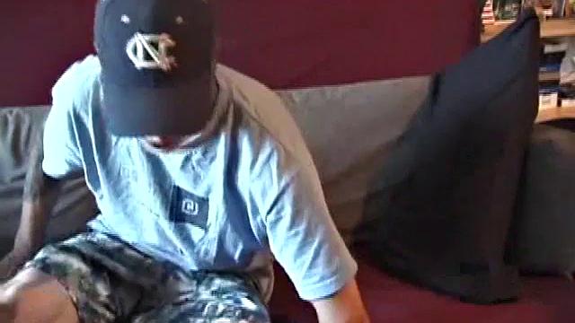 Young amateur Brandon reclines on the sofa and pulls off his pants. Watching porn video, he rubs his dick hard and fingers his asshole.