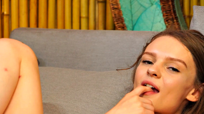 рыжая худышка с тату ласкает себя на диване и жует палец