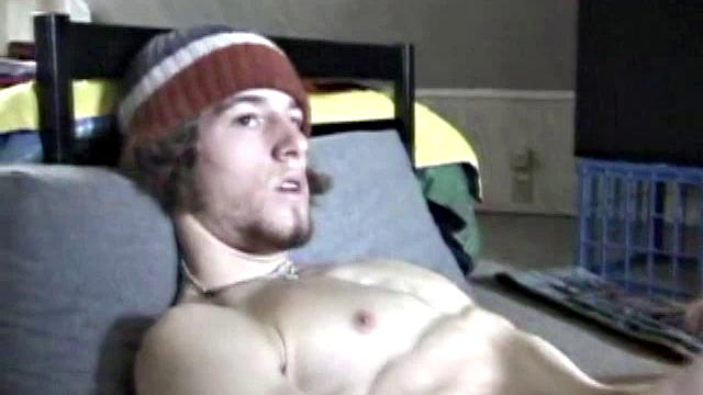 Adam relaxes on the floor watching porn video, strokes cock, plays with butthole, and blasts cum load onto skateboard