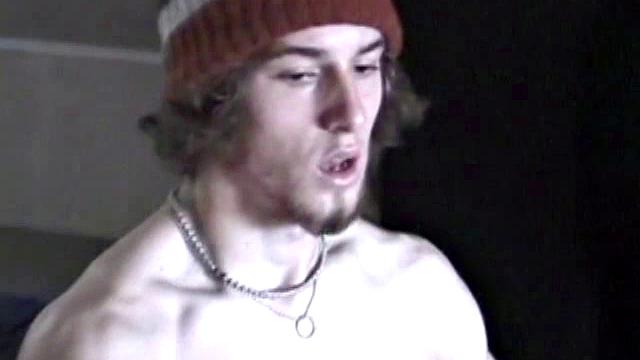 Adam relaxes on the floor watching porn video, strokes cock, plays with butthole, and blasts cum load onto skateboard