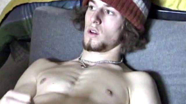 Adam relaxes on the floor watching porn video, strokes cock, plays with butthole, and blasts cum load onto skateboard