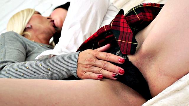 Watch this busty blonde girlfriend finger, lick, and kiss her busty girlfriend's tight bald pussy on the sofa