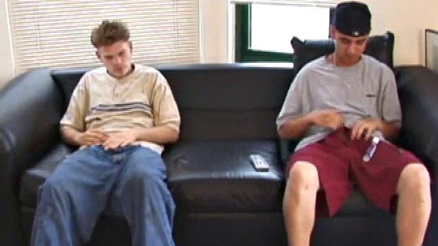 Christian and Richie sit on the sofa, watching a porn video while slowly rubbing their crotches. Richie shyly takes out his dick and watches as Christian strips off his shorts and exposes an impressive cock.
