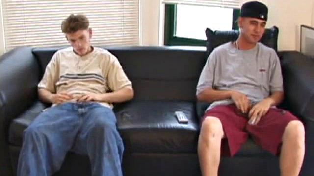 Christian and Richie sit on the sofa, watching a porn video while slowly rubbing their crotches. Richie shyly takes out his dick and watches as Christian strips off his shorts and exposes an impressive cock.