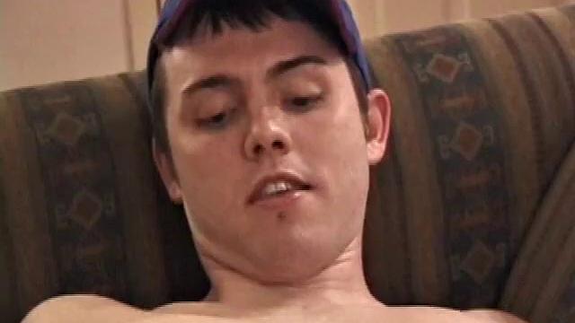 Christian Dane strips down to his underwear. When they are eventually removed we see this skinny little boy has a great big dick. He moves from sofa to the bed, all the while fingering his ass and balls while steadily stroking.