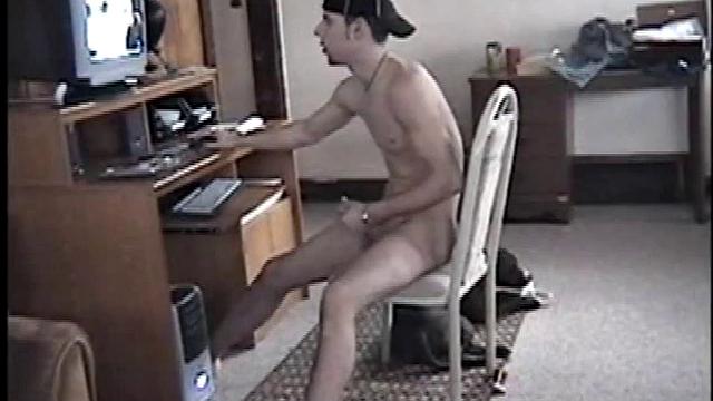 Shadow plants himself in front of the computer, starts stroking his dick to the porn video playing. As he works the keyboard and mouse he massages his cock and in no time the young man is pumping cum on his six pack