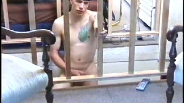 Dressed in baggy shorts and a baseball cap, popular Shane stands halfway up the stairs, watching his porno and talking about making the wall the target for his cum shot.