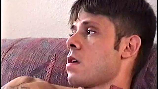 This tattooed misfit quickly strips down, lubes up, and strokes on the sofa.