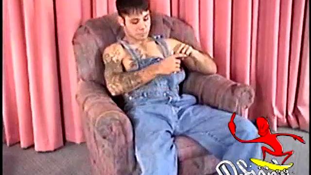 This tattooed misfit quickly strips down, lubes up, and strokes on the sofa.