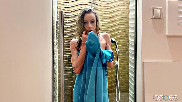 Curly-haired babe with tattoos enjoys solo play in the shower with dildo