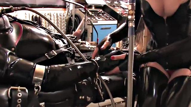 BDSM domina in leather pumping sub's pathetic cock