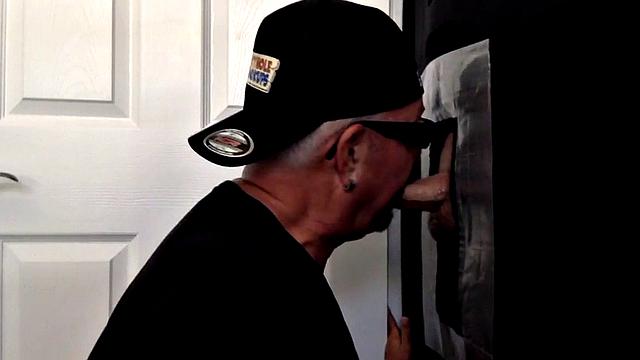 Senior gloryhole amateur blows BF's dick through hole
