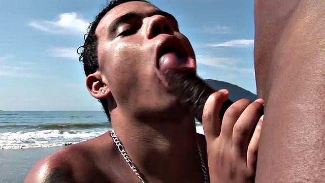 On a secluded rock covered section of the beach, Brazilian studs Roberth and Roger are naked and sunbathing, when the mood strikes. The muscular top stands and offers his uncut cock for some Latino lips to suck on it.