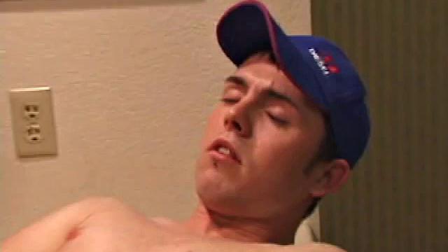 Christian Dane strips down to his underwear. When they are eventually removed we see this skinny little boy has a great big dick. He moves from sofa to the bed, all the while fingering his ass and balls while steadily stroking.