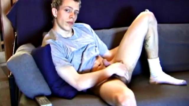 Young Shane relaxes on the sofa while watching a porn video and gets totally into himself. He delivers a nice long stroke show, before shooting onto his t-shirt.