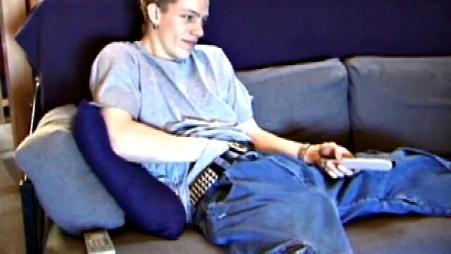 Young Shane relaxes on the sofa while watching a porn video and gets totally into himself. He delivers a nice long stroke show, before shooting onto his t-shirt.
