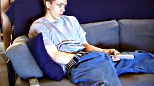 Young Shane relaxes on the sofa while watching a porn video and gets totally into himself. He delivers a nice long stroke show, before shooting onto his t-shirt.