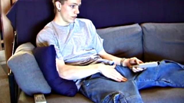 Young Shane relaxes on the sofa while watching a porn video and gets totally into himself. He delivers a nice long stroke show, before shooting onto his t-shirt.