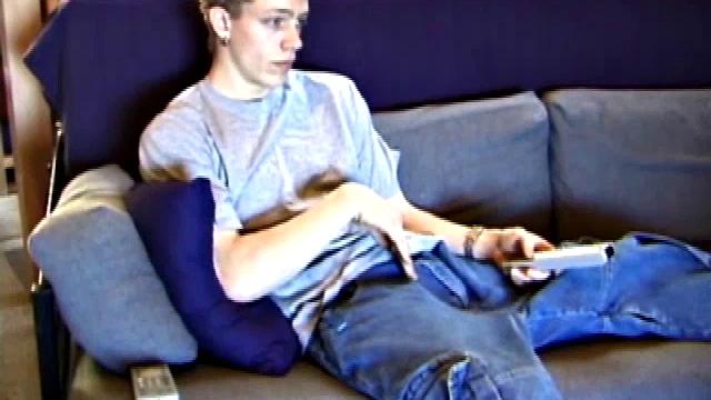 Young Shane relaxes on the sofa while watching a porn video and gets totally into himself. He delivers a nice long stroke show, before shooting onto his t-shirt.