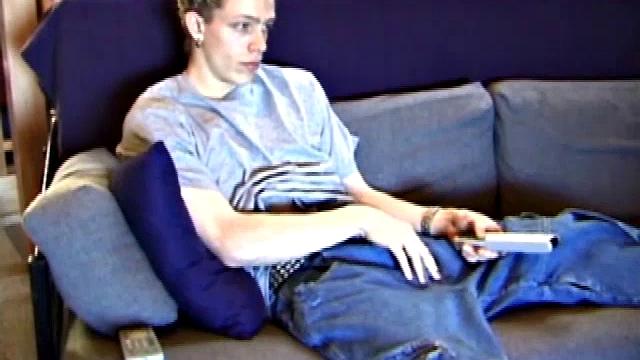 Young Shane relaxes on the sofa while watching a porn video and gets totally into himself. He delivers a nice long stroke show, before shooting onto his t-shirt.