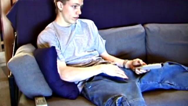 Young Shane relaxes on the sofa while watching a porn video and gets totally into himself. He delivers a nice long stroke show, before shooting onto his t-shirt.
