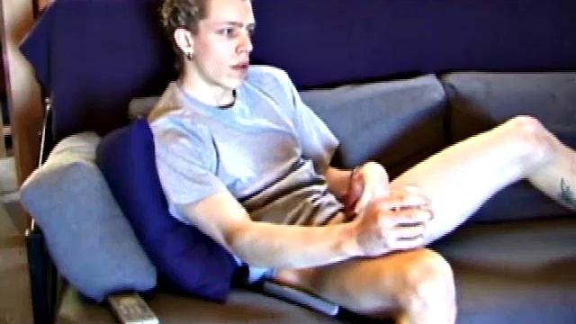 Young Shane relaxes on the sofa while watching a porn video and gets totally into himself. He delivers a nice long stroke show, before shooting onto his t-shirt.