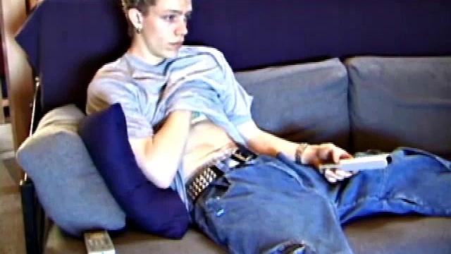 Young Shane relaxes on the sofa while watching a porn video and gets totally into himself. He delivers a nice long stroke show, before shooting onto his t-shirt.