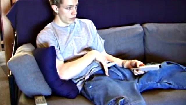 Young Shane relaxes on the sofa while watching a porn video and gets totally into himself. He delivers a nice long stroke show, before shooting onto his t-shirt.