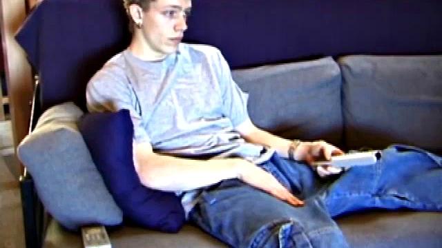 Young Shane relaxes on the sofa while watching a porn video and gets totally into himself. He delivers a nice long stroke show, before shooting onto his t-shirt.