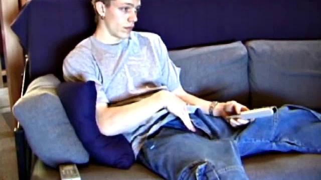 Young Shane relaxes on the sofa while watching a porn video and gets totally into himself. He delivers a nice long stroke show, before shooting onto his t-shirt.