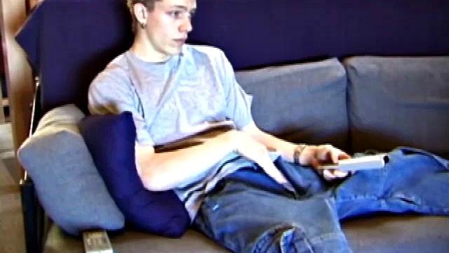 Young Shane relaxes on the sofa while watching a porn video and gets totally into himself. He delivers a nice long stroke show, before shooting onto his t-shirt.