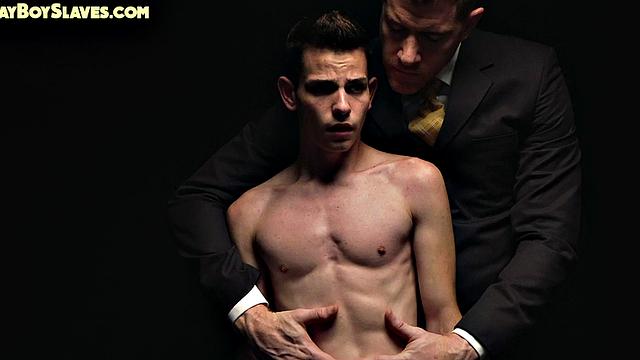 Dominant suited DILF jerks cock of skinny oiled twink