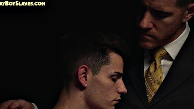 Dominant suited DILF jerks cock of skinny oiled twink