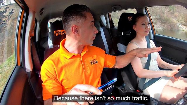 Asian driving learner throating and riding instructor in car