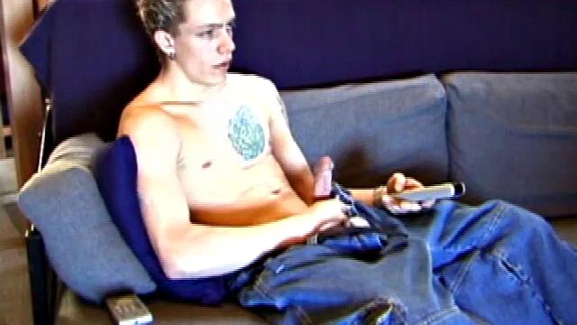 Shane relaxes on the sofa, while watching a porn video and gets totally into himself. He works his lubed up cock with determination and pumps out a big cum gusher.