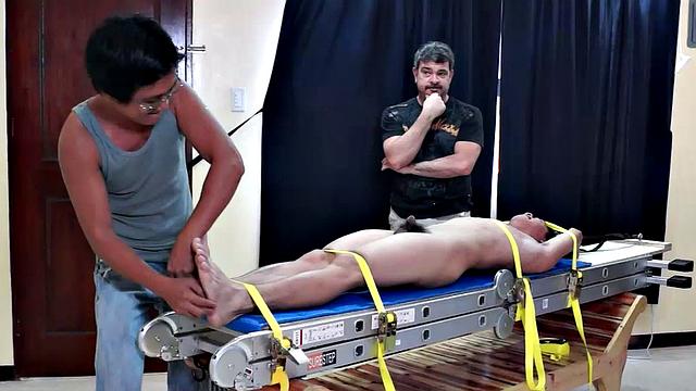 Diamond collectors have captured a thief who's been stealing diamonds from them. They've strapped him down on a rack and intend to tickle the cute young Asian boy until he breaks. They've got all day if necessary.