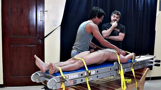 Diamond collectors have captured a thief who's been stealing diamonds from them. They've strapped him down on a rack and intend to tickle the cute young Asian boy until he breaks. They've got all day if necessary.