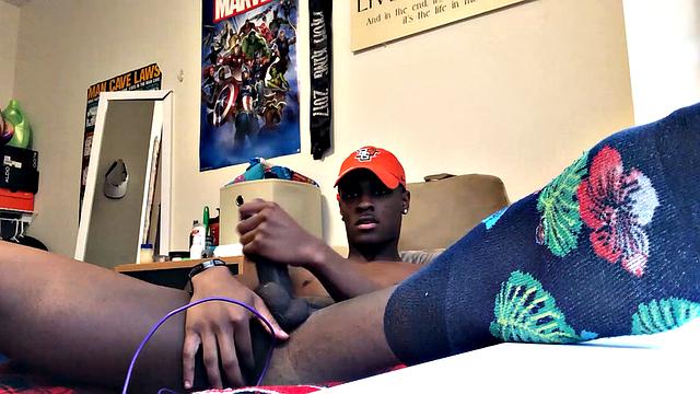 We find Chris in his bedroom, as he strips naked and quickly gets that big dick of his stiff and ready for stroking. Wearing nothing but a ball cap and sox, this young ebony stud is all over the room, while he chases a climax.