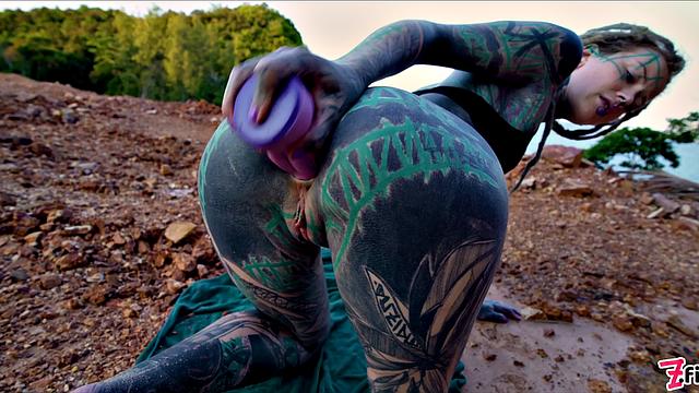 татуированная шалунья дрочит себе в жопу на улице и устраивает золотой дождь