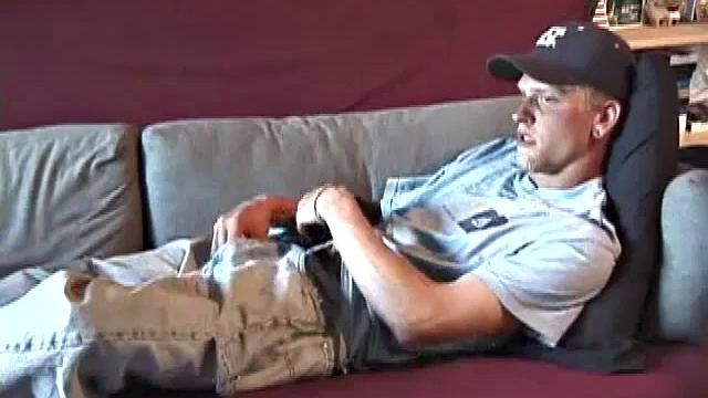 Young amateur Brandon reclines on the sofa and pulls off his pants. While watching a video, he rubs his cock hard and fingers his ass.