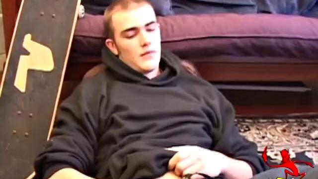 After coming back from skateboarding, Christian Wilde gets a stiff one thru his pants and pulls it out. Some double-handed stroking finally sends a cum gusher onto his chest.