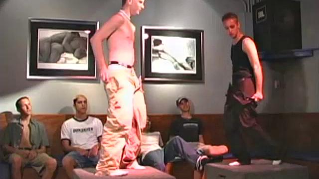 Evan and Zachary are stripping naked and dancing at the local bar, surrounded by fans.