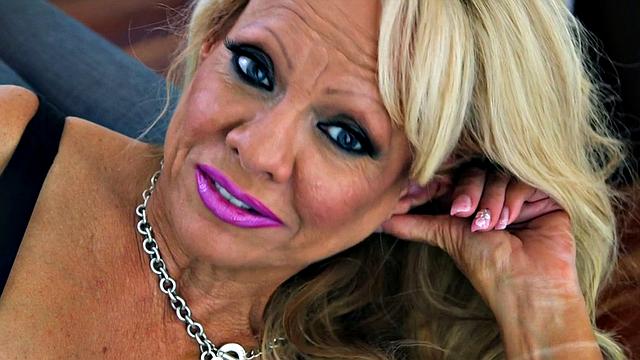 зрелая блондинка дрочит в сетчатых чулках и показывает грудь